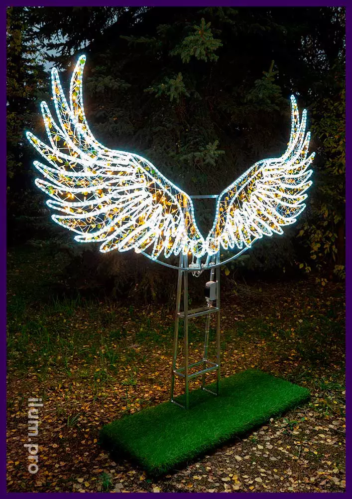 Большие светящиеся крылья ангела из металлического каркаса подсвечены гирляндами и декорированы прозрачными, пластиковыми элементами с блёстками