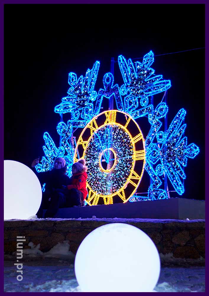 Светодиодная фотозона с уличными гирляндами и дюралайтом в форме большой снежинки с часами в Копейске