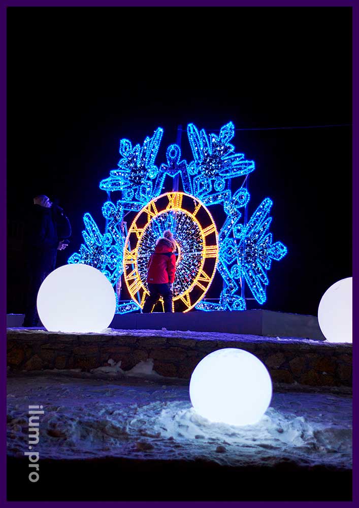 Новогоднее украшение парка в Копейске светящимися часами в форме снежинки из гирлянд