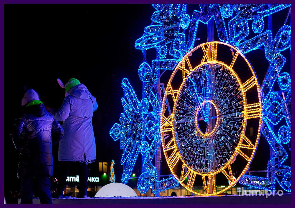 Новогоднее украшение сквера фотозоной в форме большой снежинки с часами из гирлянд