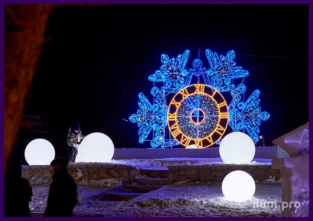 Уличная фотозона в форме снежинки из гирлянд и часов из дюралайта для украшения площади на Новый год