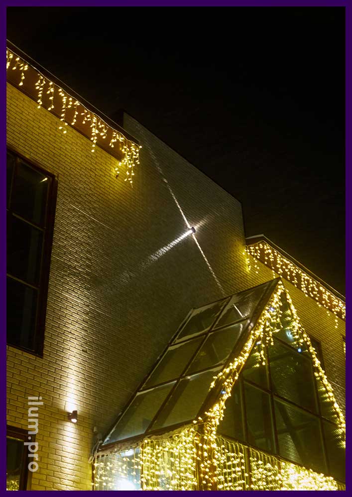 Новогодняя подсветка фасада здания в Нарьян-маре уличными гирляндами тёплых оттенков белого цвета
