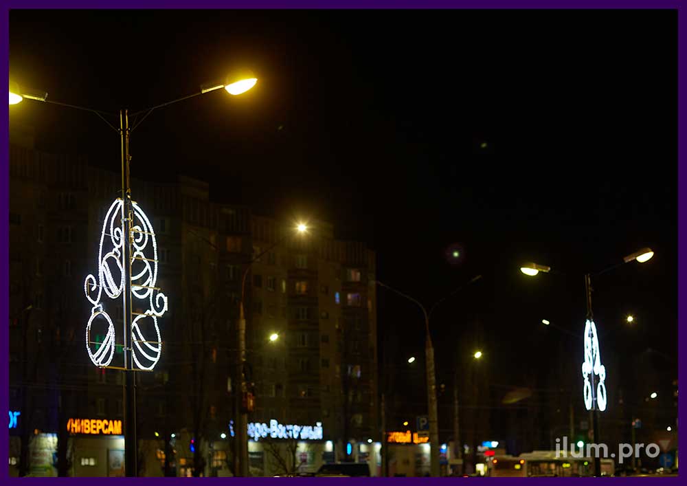 Украшение фонарей рядом с ТЦ новогодними консолями в форме ёлочных шаров