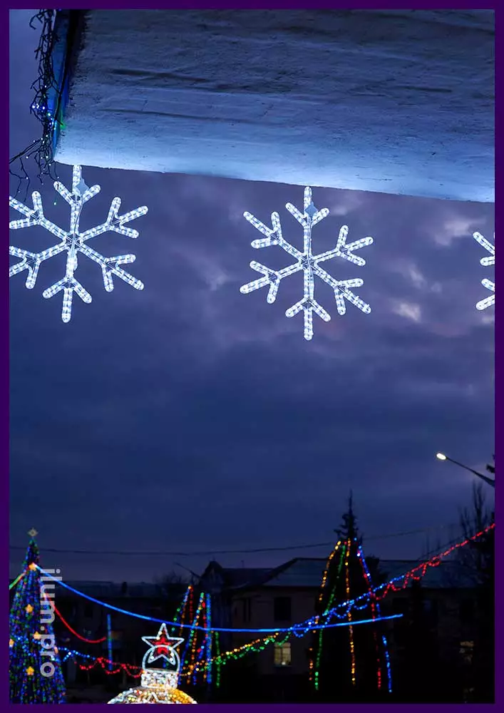 Снежинки из светодиодного дюралайта на фасаде здания на Новый год