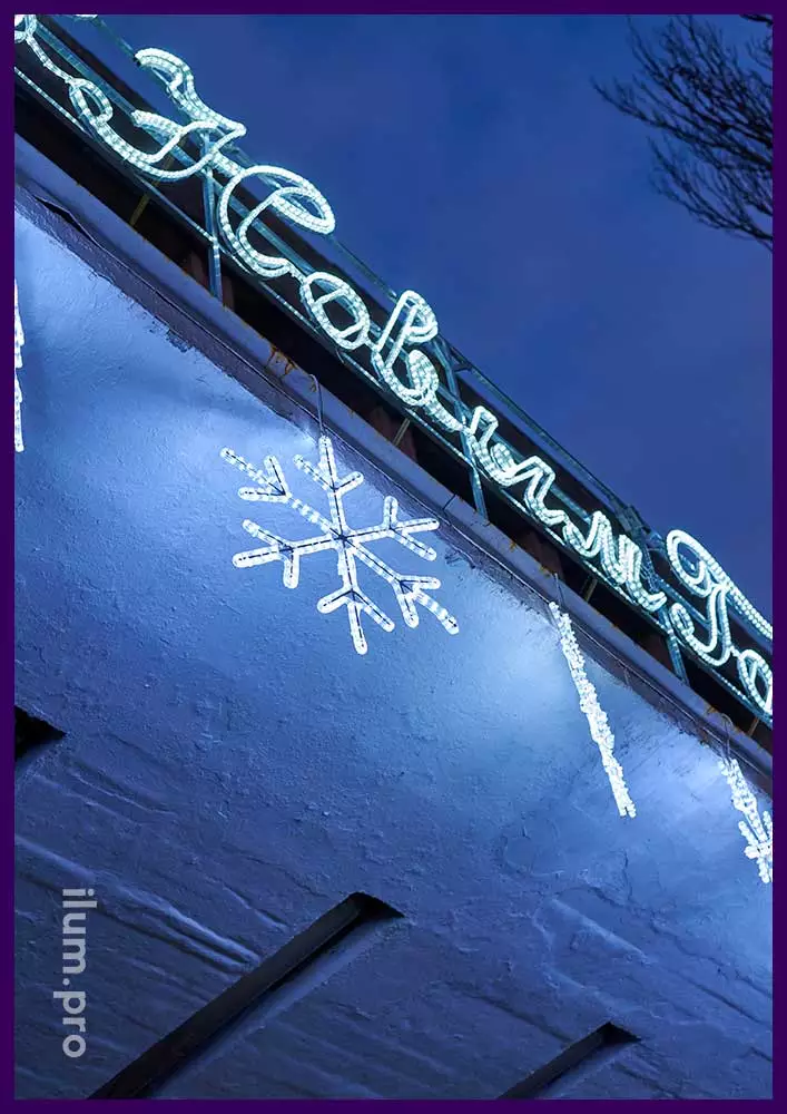 Новогодние снежинки из светодиодного дюралайта белого цвета на фасаде здания