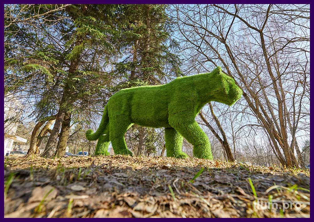 Пушистая фигура тигра из искусственной травы зелёного цвета в городском парке