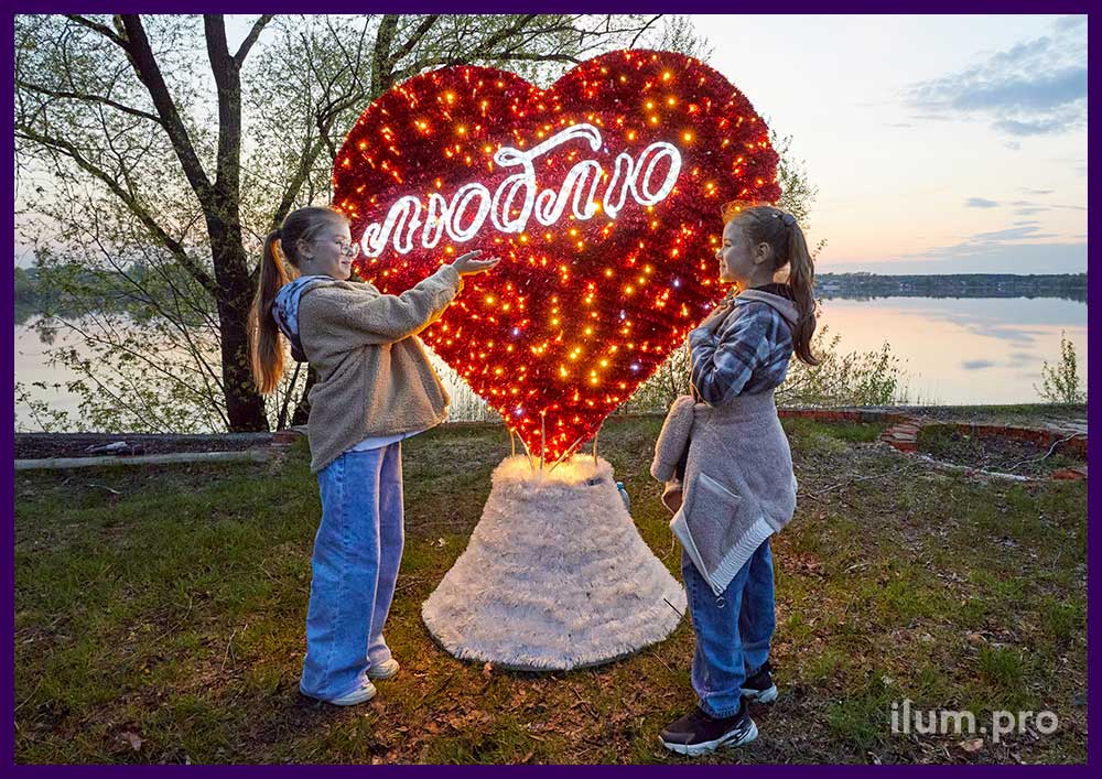 Красное сердце с белым словом Люблю - уличная фотозона на набережной озера