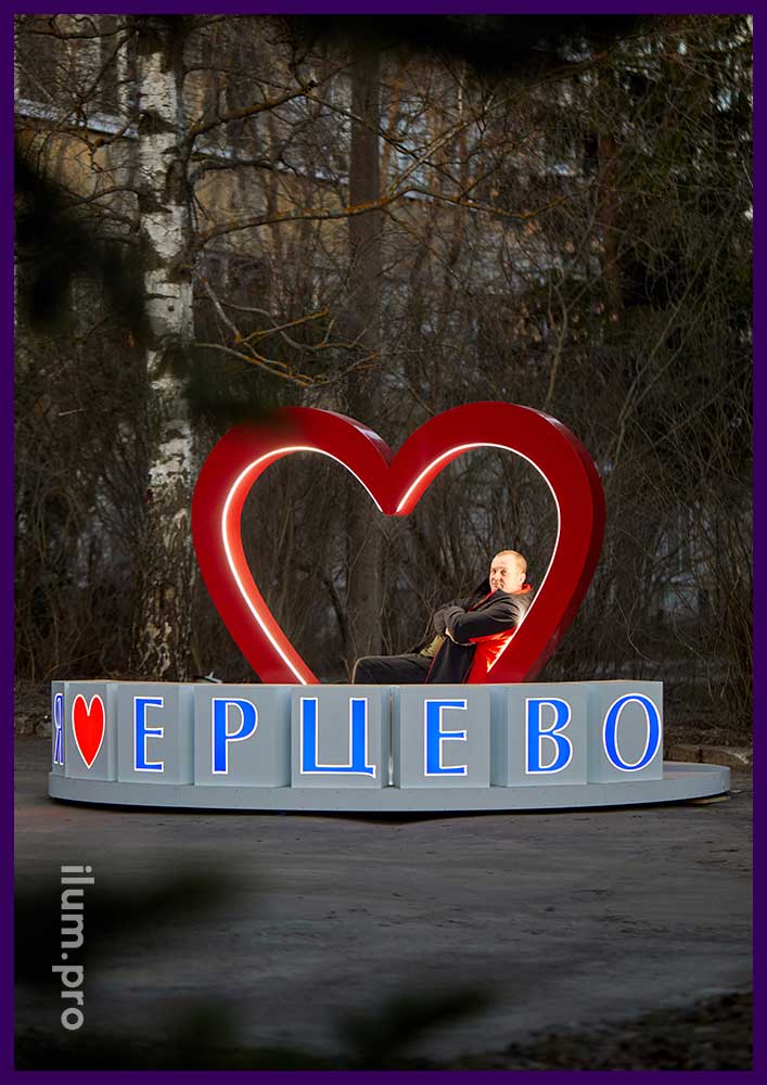 Красное сердце с лавочкой и белые кубы с надписью на цилиндрическом подиуме - фотозона для города