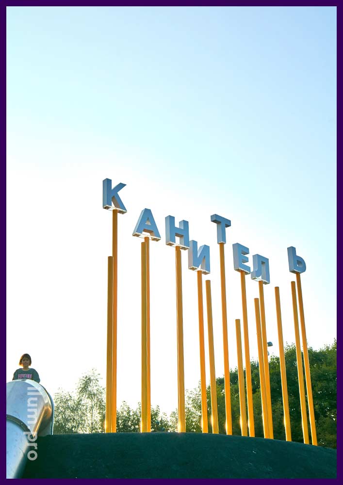 Фотозона в виде надписи Канитель из акриловых букв на столбах жёлтого цвета в Москве