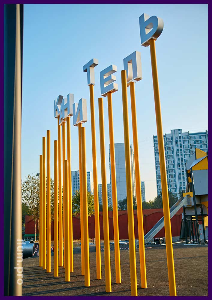Уличная фотозона с крупными буквами из акрила и жёлтыми трубами из оцинкованной стали
