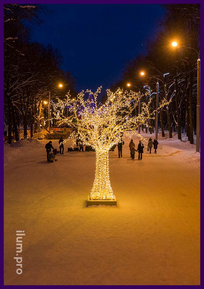 Нержавеющие деревья в городском парке с подсветкой уличной иллюминацией