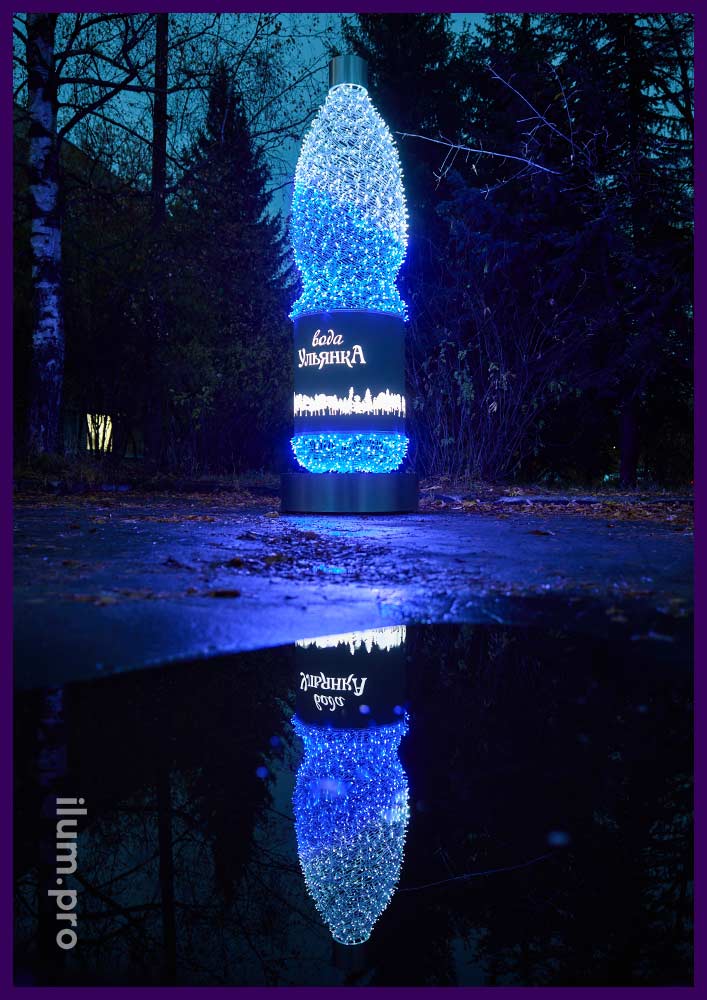 Разноцветная бутылка воды с гирляндами - уличная фотозона на подиуме