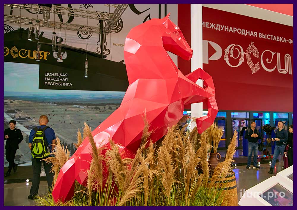 Ярко-красная скульптура коня на дыбах на выставке Россия