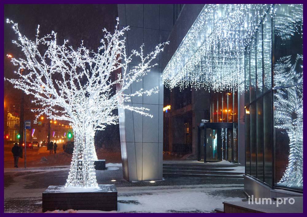 Белые деревья с иллюминацией для украшения улицы на Новый год
